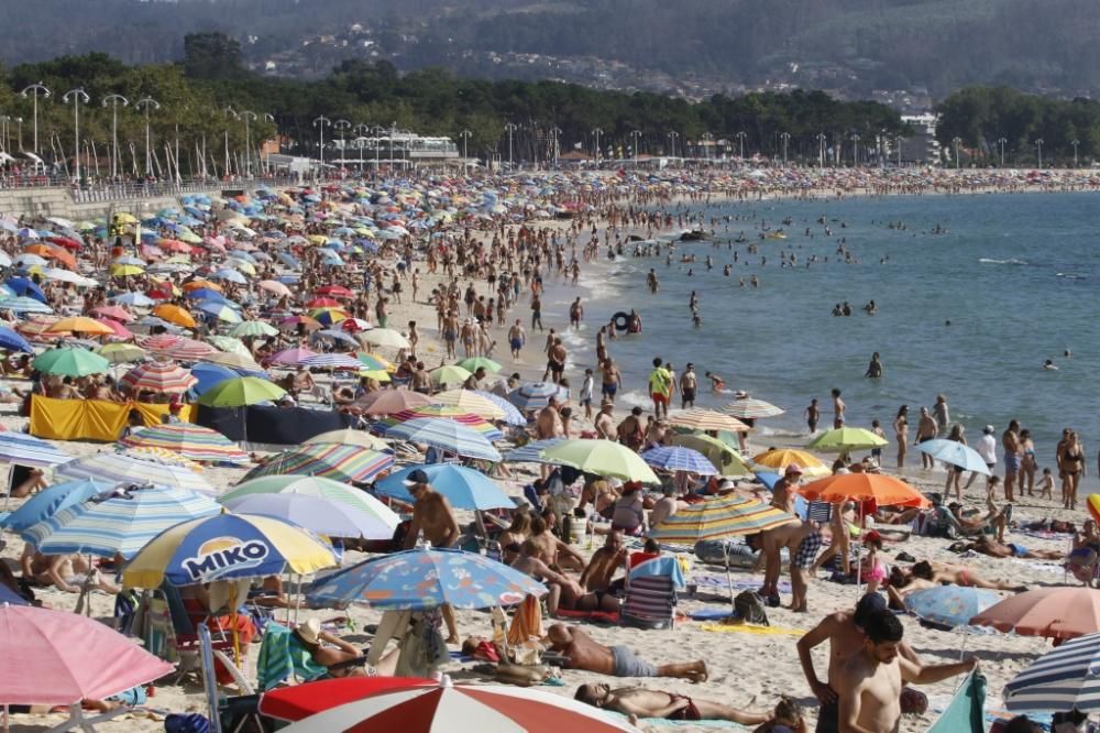 El buen tiempo anima a los bañistas en la playa de Samil