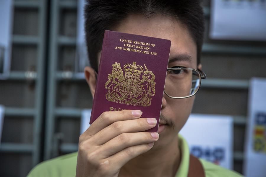Un hongkonés posa con su pasaporte británico.