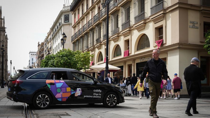 Un vehículo VTC circula por una calle del centro de Sevilla.