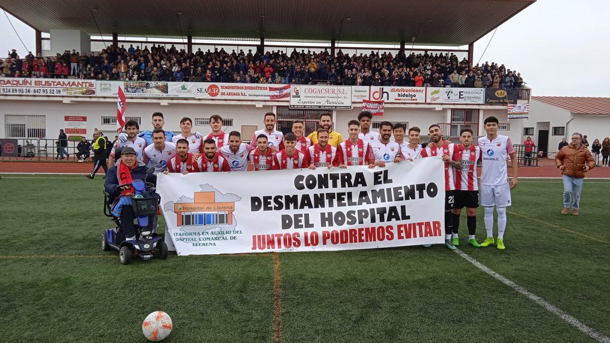 Los jugadores de Azuaga y Llerenense, juntos con una pancarta contra el desmantelamiento del hospital comarcal.