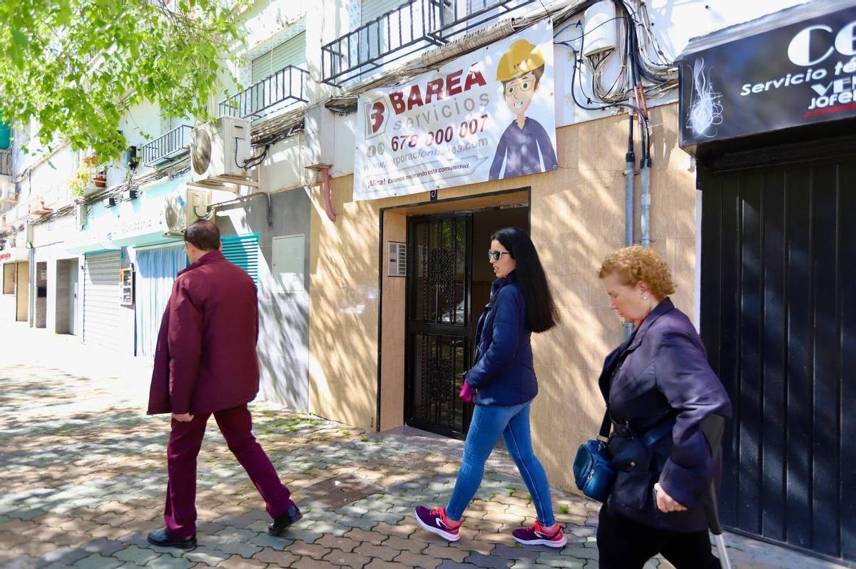 Varias personas pasando por el portal de la vivienda del fallecido en Sagunto.