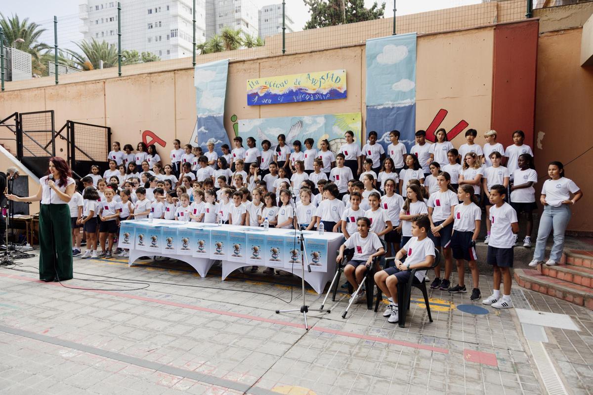 La presidenta de la Asociación de Libreros de Las Palmas, Irene Pérez, delante del coro infantil del proyecto 'Un libro es' del CEIP Mesa y López y CEIP Alcaranaveras, durante la presentación de la XXXV Feria del Libro de Las Palmas.