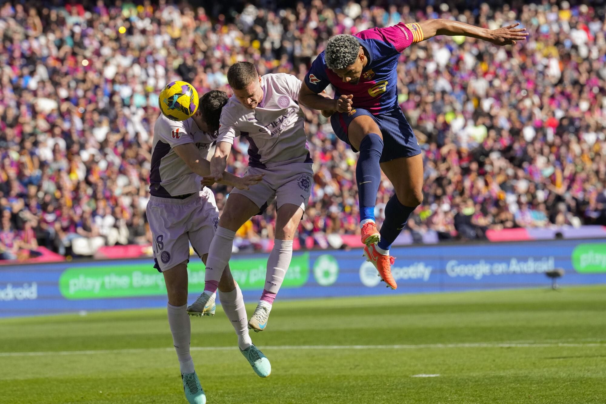 BARCELONA, 30/03/2025.- El defensa del Barcelona Ronald Araujo, el defensa del Girona Ladislav Krejci y el centrocampista del Girona Viktor Tsygankov, durante el partido de la jornada 29 de LaLiga que FC Barcelona y Girona disputan este domingo en el estadio Lluis Companys de Barcelona. EFE/ Alejandro García