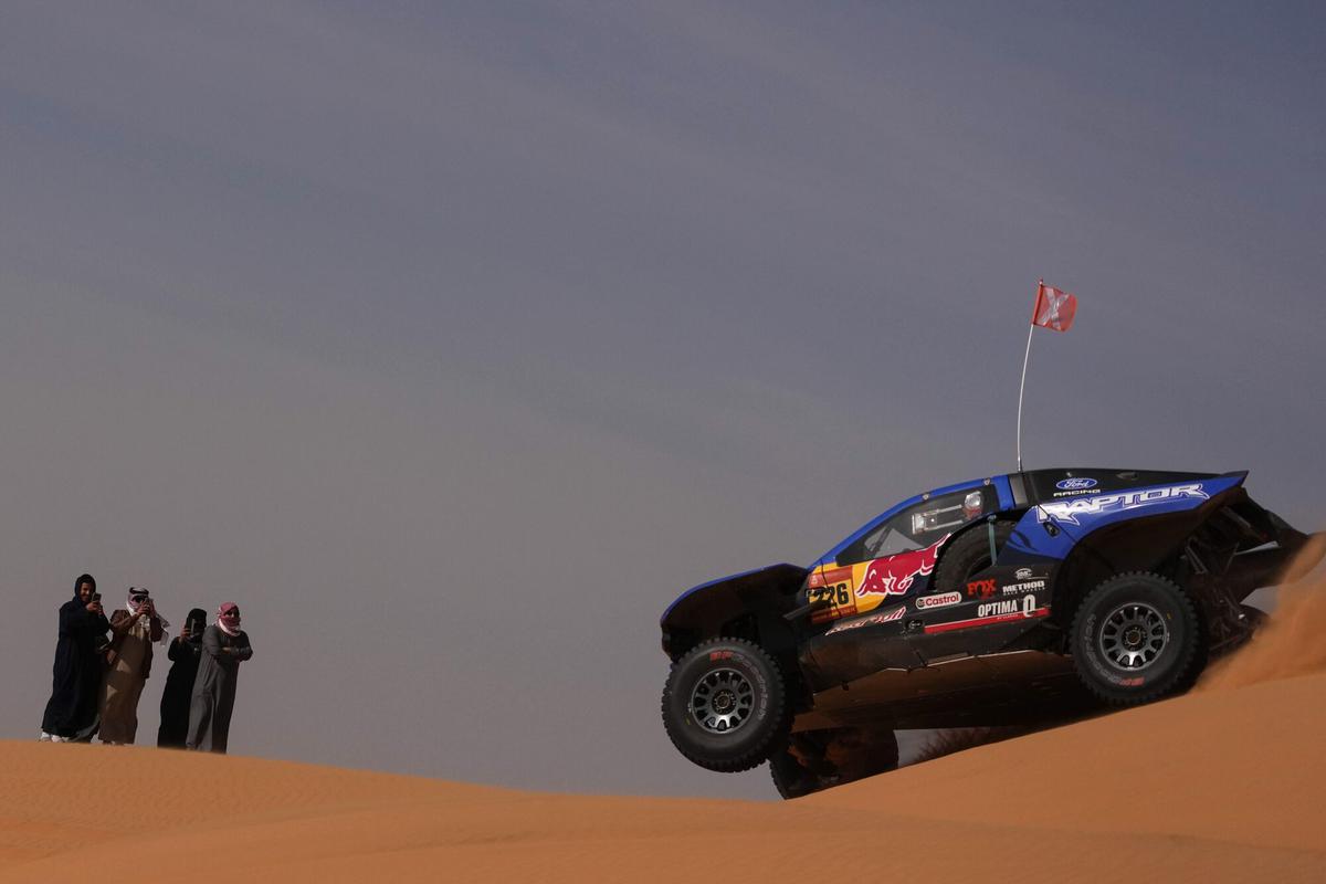 Spectators watch driver Mattias Ekstrom and co-driver Emil Bergkvist competing during the sixth stage of the Dakar Rally between Hail and Riyadh, Saudi Arabia, Friday, Jan. 9, 2026. (AP Photo/Thibault Camus)