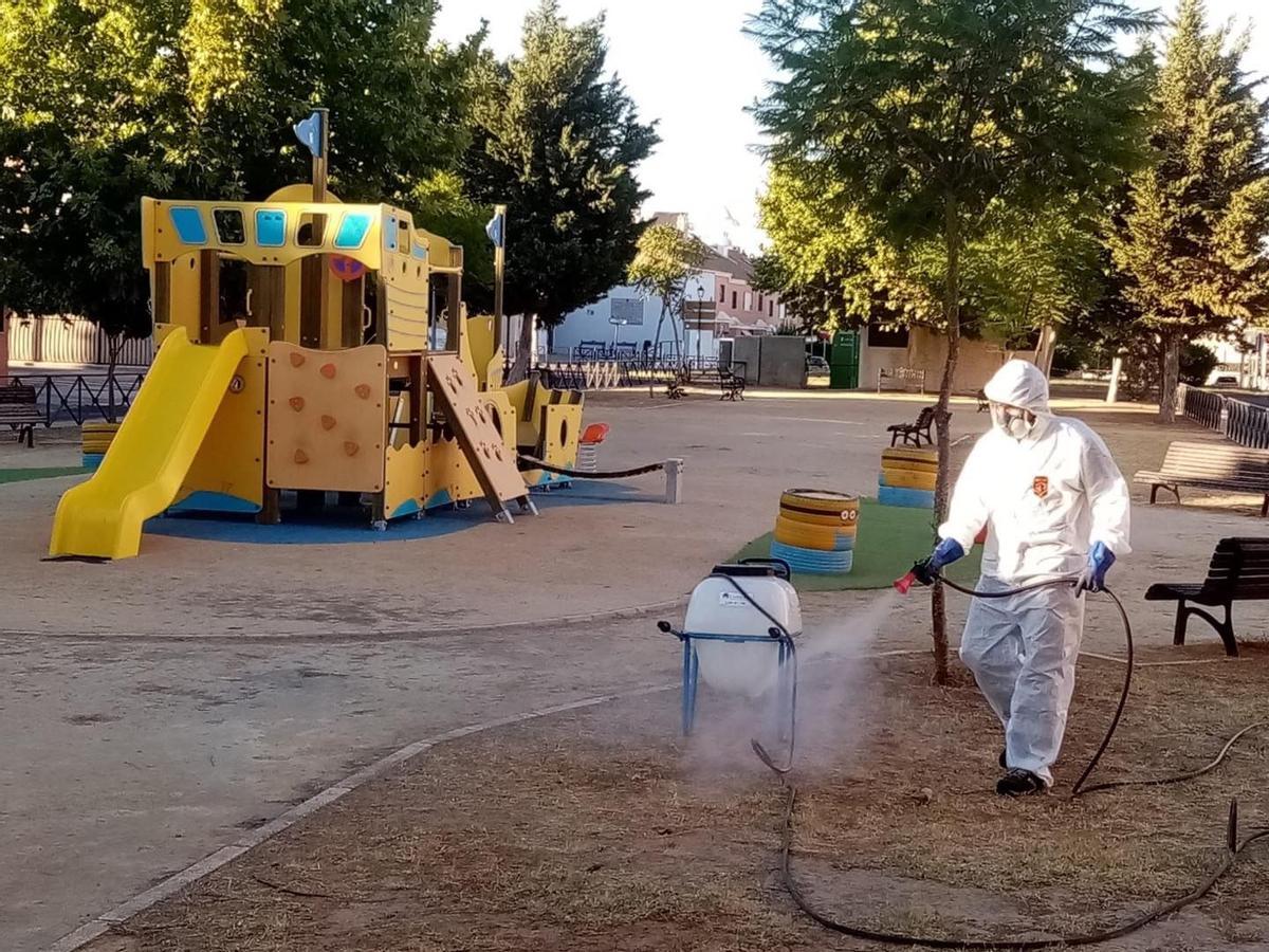 Un hombre fumiga un parque infantil para luchar contra el mosquito. /