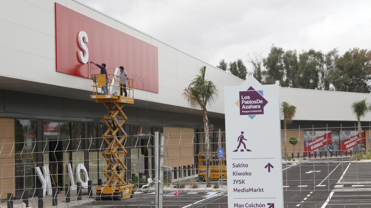 Unos operarios ultiman los detalles en una de las tiendas del parque.