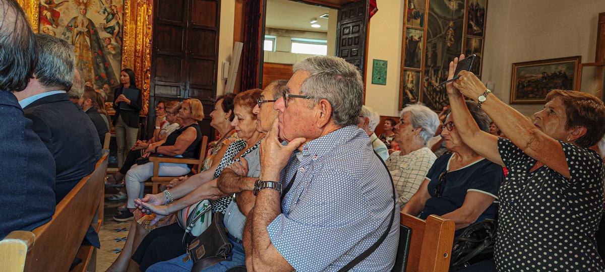 Vecinos escuchan la lectura del manifiesto por el Día del Mayor en el salón de plenos de Elche