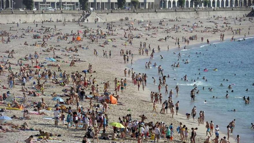 Cientos de bañistas en la playa del Orzán en julio.