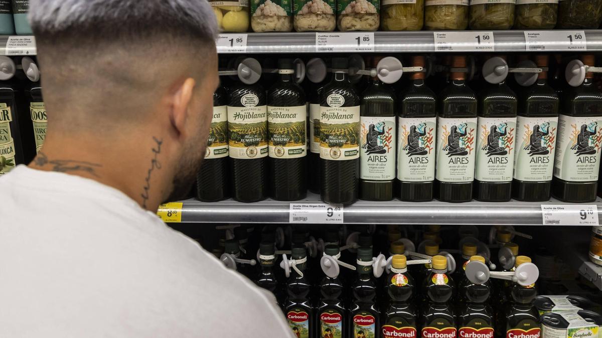 Un joven mira las distintas opciones de aceite disponibles en una cadena de supermercados en imagen de archivo.