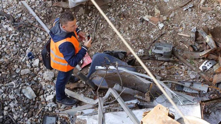 Un perito inspecciona los restos del tren.