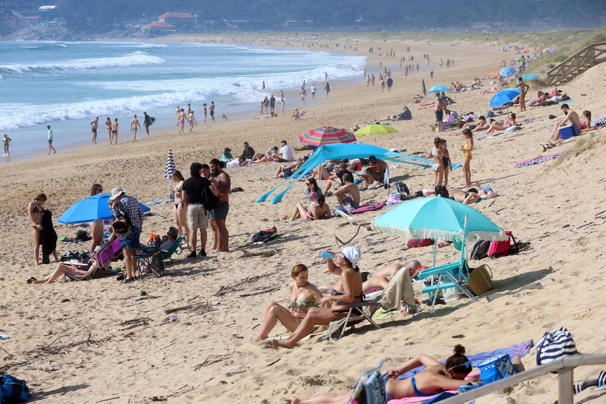 Arousanos y turistas disfrutan en las playas de un anticipio del verano.