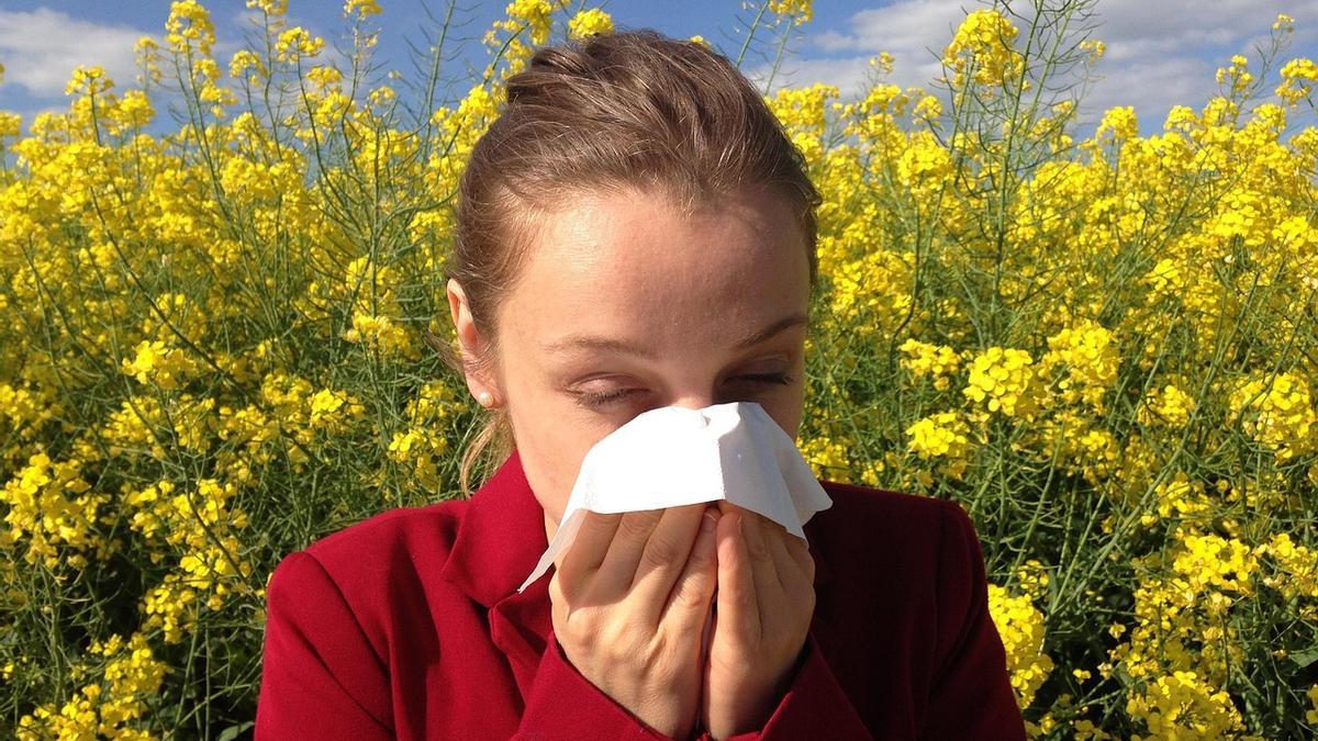 Una mujer se limpia la nariz por la alergia