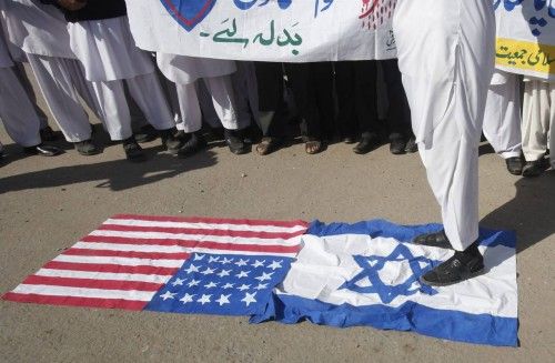A supporter of Islami Jamiat Talaba stands on Israeli flag during anti-American and anti-Israeli demonstration in Peshawar