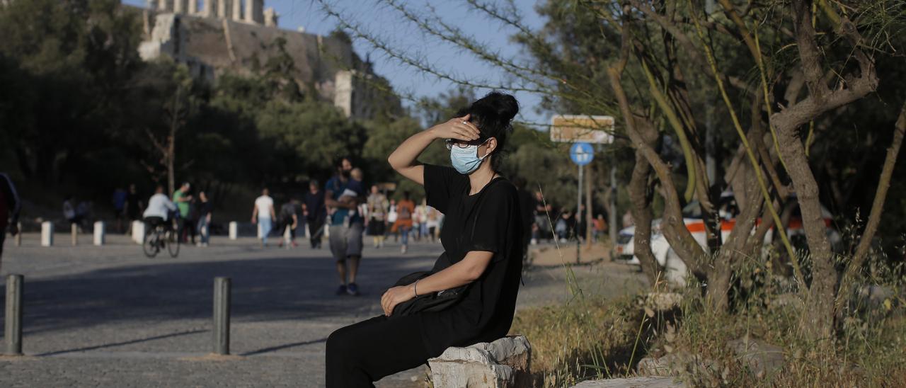 Una joven con mascarilla en el centro de Atenas
