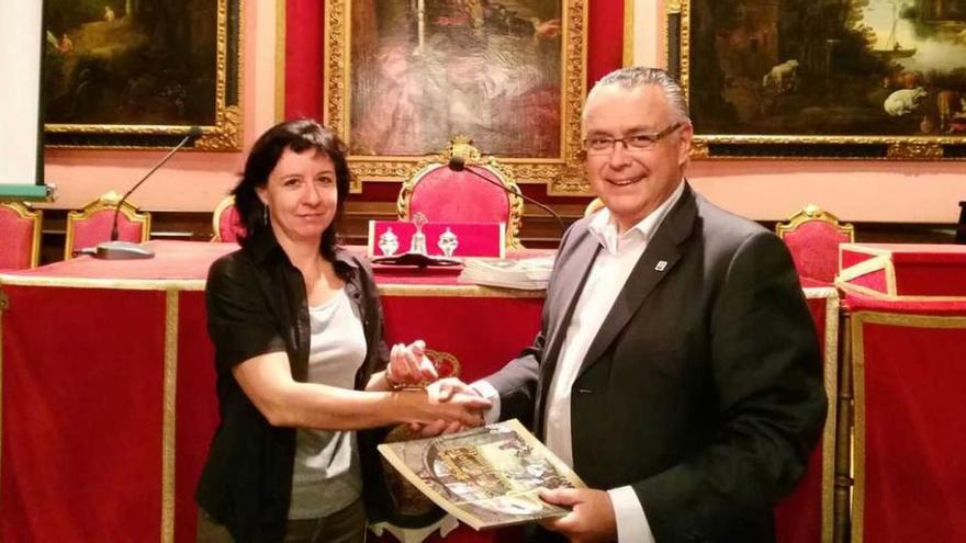 Alicia Muñoz, secretaria de la sociedad madrileña, recibe el álbum de vitolas del Quijote de manos de Juan García.