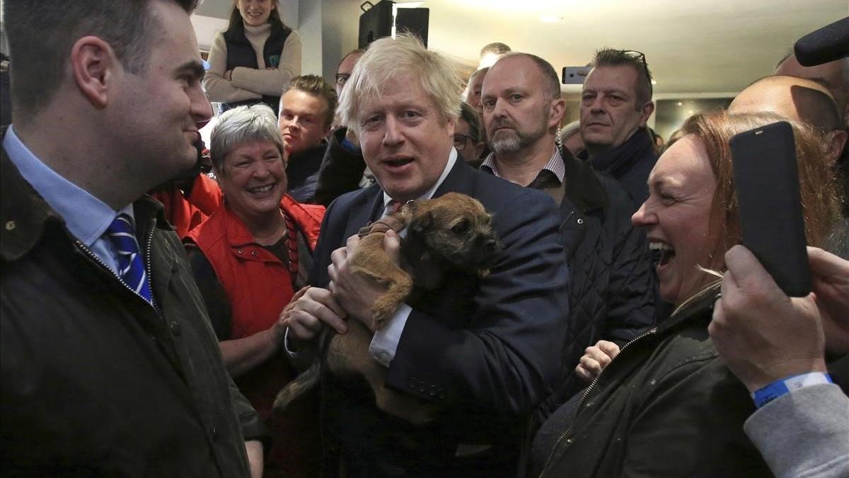 El primer ministro británico, Boris Johnson, sostiene un perro durante un encuentro con Paul Howell, el recién elegido diputado del Partido Conservador en Sedgefield, en el noreste de Inglaterra.