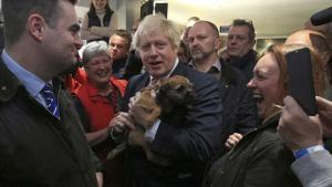 El primer ministro británico, Boris Johnson, sostiene un perro durante un encuentro con Paul Howell, el recién elegido diputado del Partido Conservador en Sedgefield, en el noreste de Inglaterra.