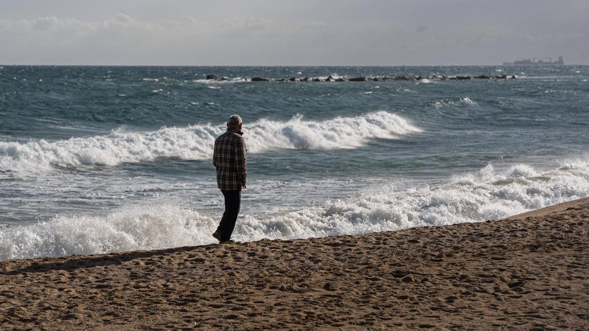Un hombre pasea en la orilla de la playa, en Barcelona.