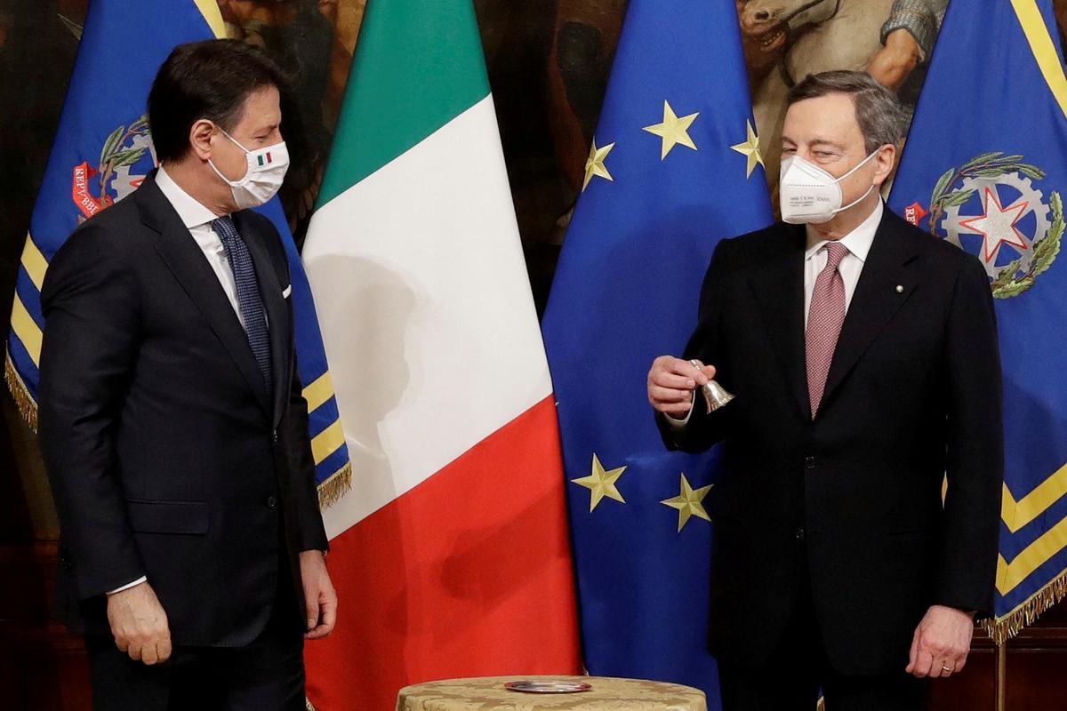El nuevo primer ministro italiano, Mario Draghi, sostiene la campana de ministro del gabinete junto al primer ministro saliente, Giuseppe Conte, durante la ceremonia de traspaso de poderes en la oficina del primer ministro del Palacio Chigi, en Roma, Italia, el 13 de febrero de 2021.