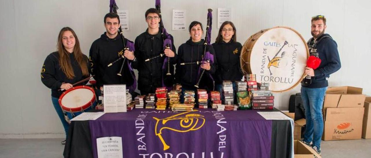 Un grupo de visitantes, ante un puesto de venta de la Feria de Comercio del mercado de abastos.