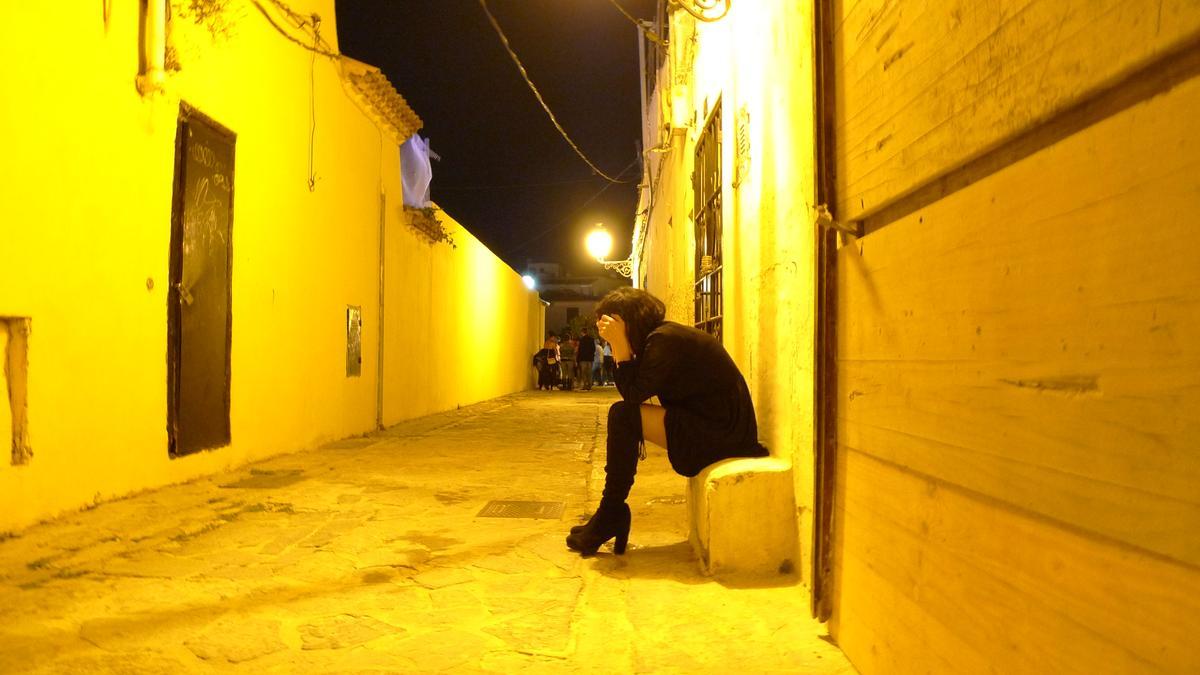 Una joven descansa en un callejón de es Jonquet durante la noche del sábado