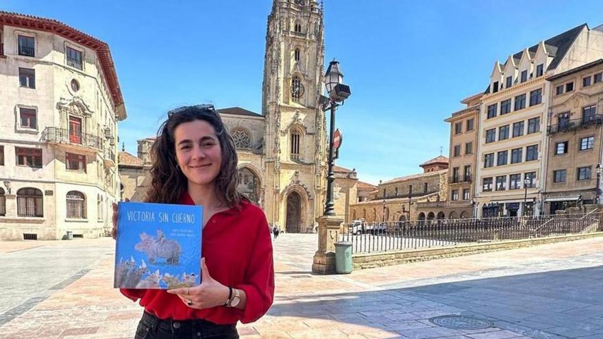 Marta Pastur posa con su libro &quot;Victoria sin cuerno&quot;, con la Catedral de Oviedo al fondo.