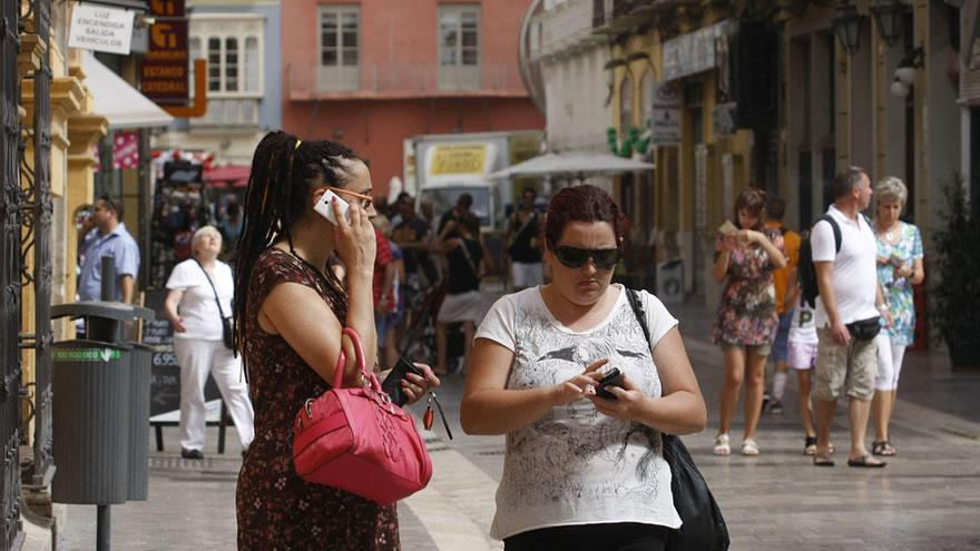 Dos mujeres utilizan su móvil en el centro de Málaga.