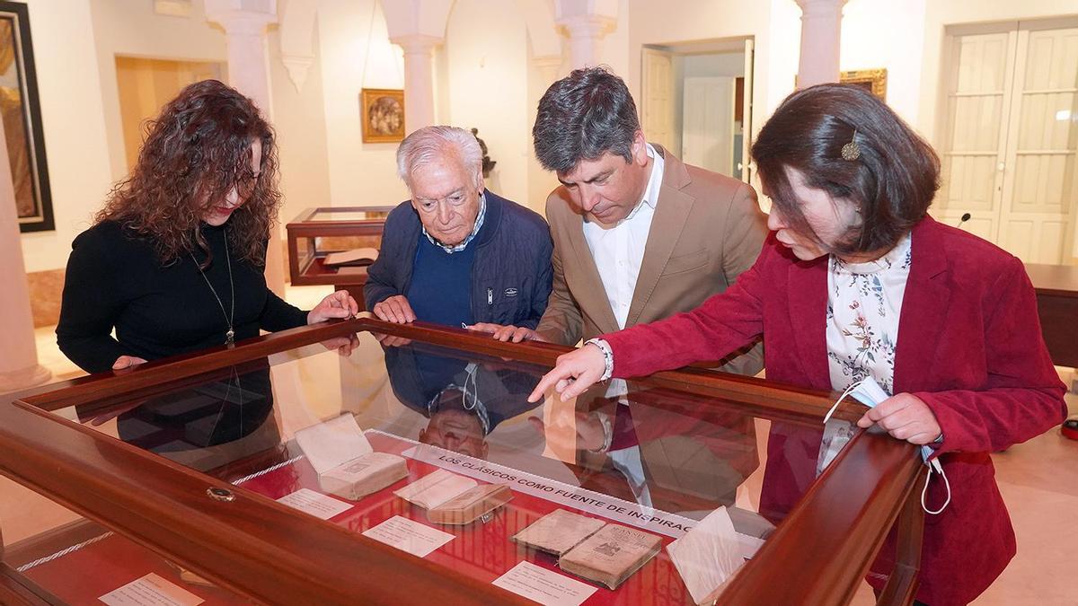 Varias personas observan una de las vitrinas de la exposición.