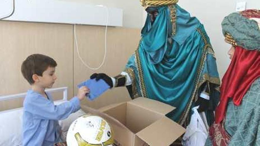 Un niño recibiendo un regalo de Baltasar en el Hospital del Vinalopó.