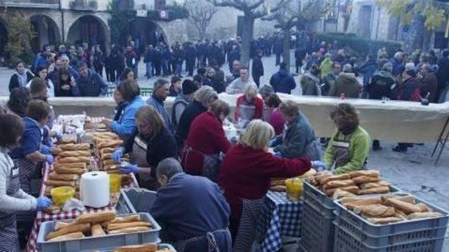 Voluntaris preparant l&#039;esmorzar, amb llargues cues al darrera