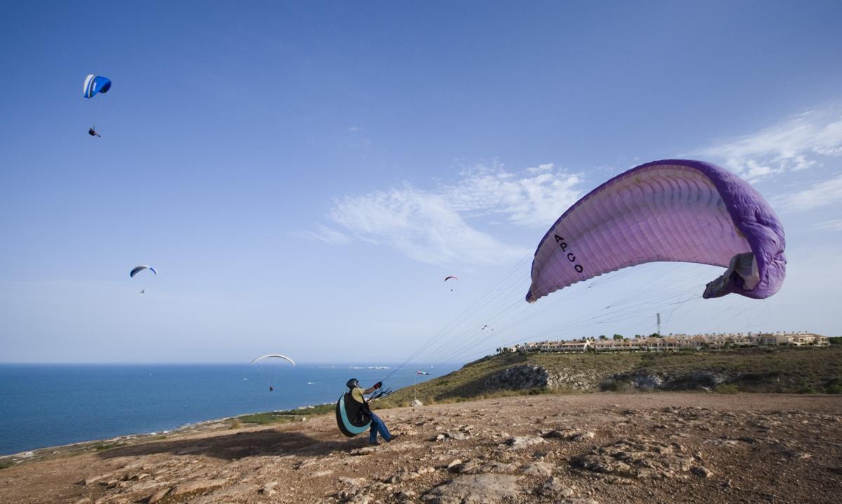Numerosos profesionales practican parapente en el faro de Santa Pola
