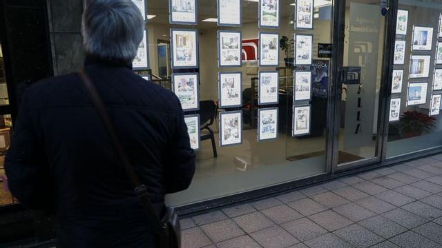 Un hombre mira la oferta de vivienda en el escaparate de una agencia inmobiliaria. | Mara Villamuza