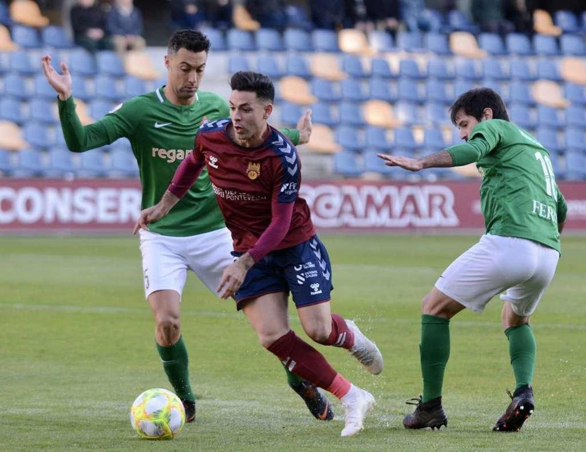 Álvaro Bustos supera a dos rivales del Racing de Ferrol en el último derbi disputado en Pasarón. // Rafa Vázquez