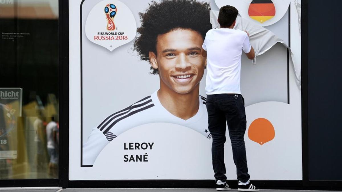 Un empleado saca el poster de Leroy Sané colgado en la fachada de la Federación Alemana
