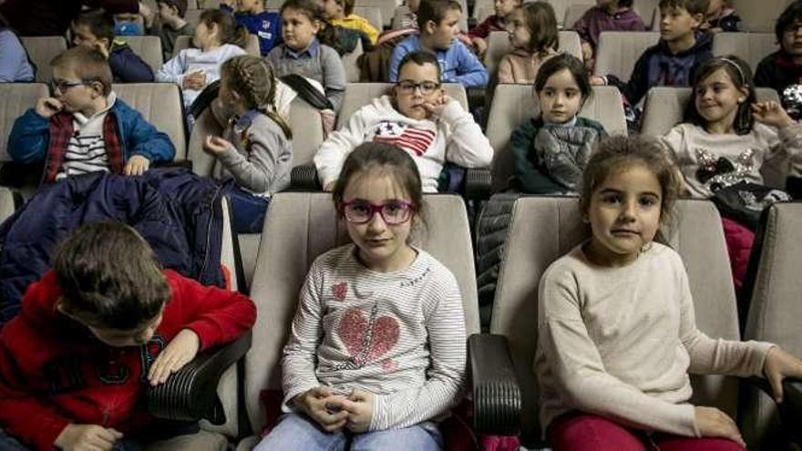 Arriba, interpretación al violonchelo de una pieza de Bach en el Conservatorio Profesional de Música de Oviedo. Debajo, los niños que asistieron al espectáculo.