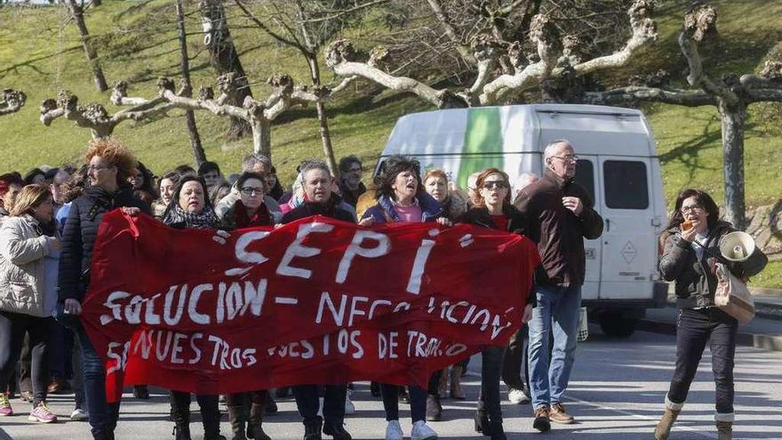 Los trabajadores del economato y vecinos de Llaranes marchan hacia la plaza Mayor.