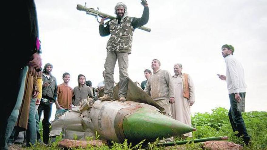 Milicianos rebeldes celebran el derribo de un caza de Gadafi en los alrededores de Bengasi.
