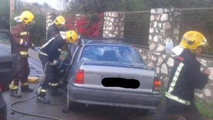 Varios bomberos tratan de liberar el cuerpo sin vida de la persona fallecida.