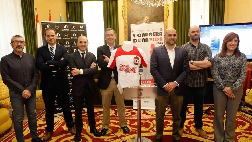 Organizadores del evento, patrocinadores y concejales posan con la camiseta de la carrera, con la inscripción de un grupo sanguíneo.