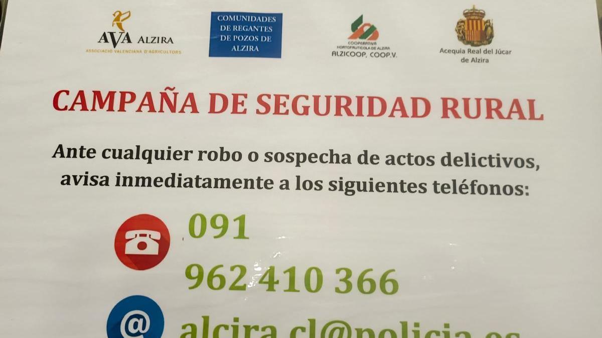 Cartel de la campaña de seguridad rural con los teléfonos de la policía que todavía está presente en el término de Alzira.