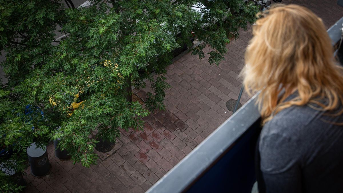 Una mujer observa el lugar donde un hombre se suicidó cuando iba a ser desahuciado en el barrio del Bon Pastor, en Barcelona.