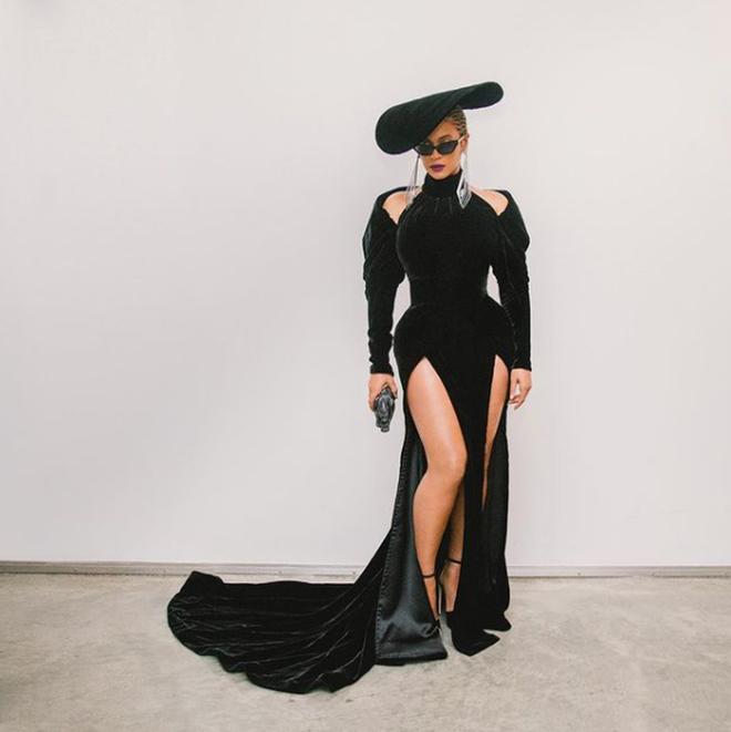 Beyoncé con vestido negro de doble abertura lateral con cola y tocado