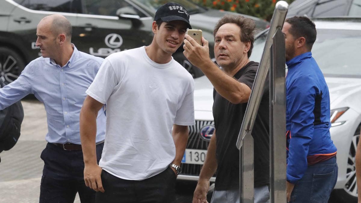 Carlos Alcaraz atiende a un aficionado, mientras entra al Hotel donde está concentrado en València junto al equipo español de Copa Davis