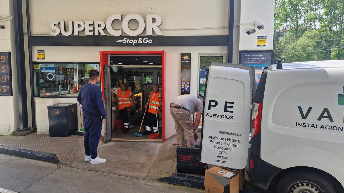 Operarios colocando la puerta rota por los asaltantes.