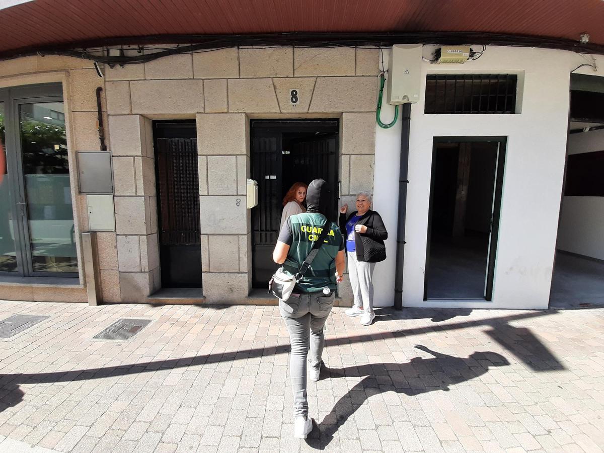 Una agente de la Guardia Civil, cubierta con pasamontañas, accede al interior del número 8 de la calle Johan Carballeira, donde se realizó uno de los registros.