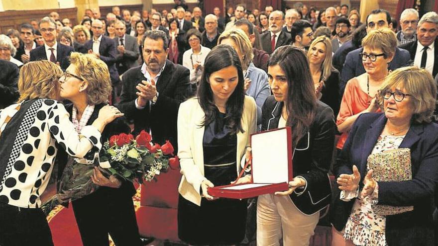 La viuda de Juan Ventura, María Jesús García de la Fuente, y sus hijas, Paula y Beatriz, reciben los obsequios que corresponden a la medalla de honor de la Universidad de Oviedo en el Paraninfo, que lucía lleno hasta la bandera.