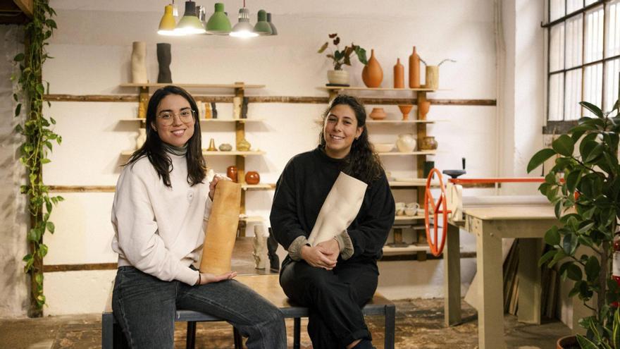 Joana Tobias i Esther Martínez mostrant dues de les seves creacions al taller d'Èter Ceràmica