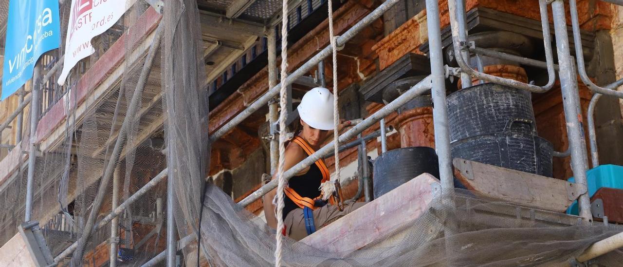 Una trabajadora en la rehabilitación de la fachada del inmueble del número 3 de Vizconde de Miranda.