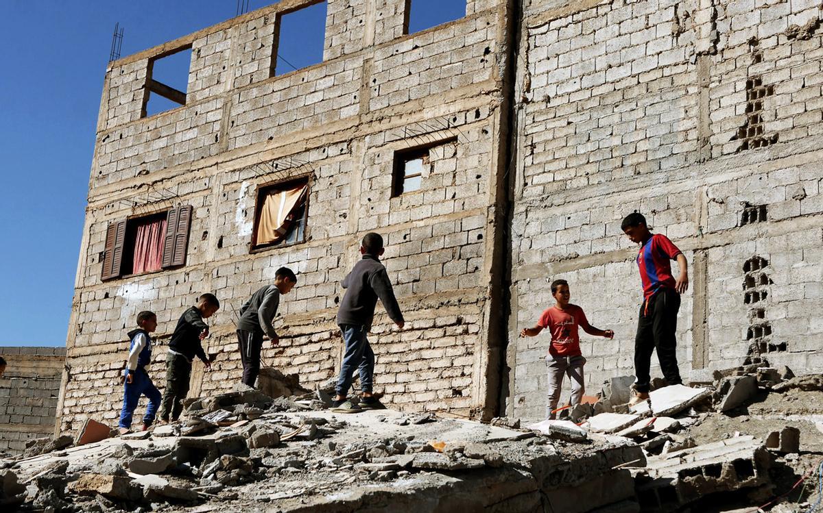 Un grupo de niños juega encima de una montaña de escombros en Amizmiz