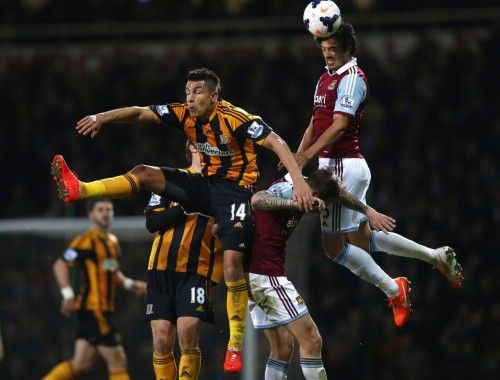 West Ham United's Tomkins challenges Hull City's Livermore during their English Premier League soccer match at the Boleyn Ground in London